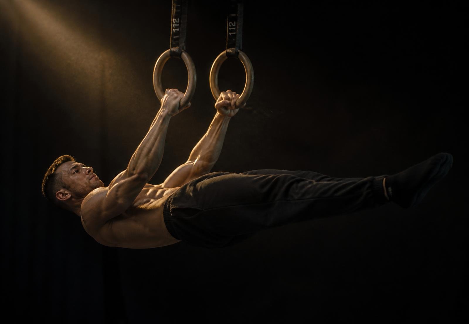 Atleta executando front lever em argolas de ginástica